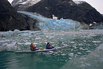 Tourists kayaking through breakaway brash ice alongside coastal glacier, Johns Hopkins Inlet, Glacier Bay NP, Alaska, USA