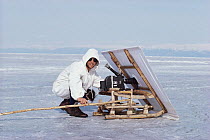 Doug Allan with camouflage gear filming seals on Lake Baikal, Siberia, at -20 degrees C.