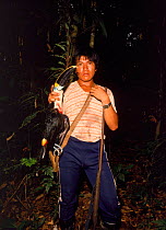 Achuar Indian with shotgun & toucan in Amazonian Ecuador