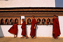 Young monks turning prayer wheels. Dzongchung Temple, Punakha, Central Bhutan