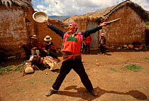 Quechua man holds silver plates at traditional wedding ceremony. Bolivia, South America