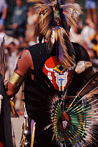 Back view of Native American in feather costume at Pow Wow dance. Wisconsin, USA