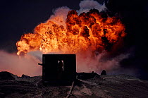 Spraying water on burning oil well from heat-shielding shed, Kuwait, post Gulf War.