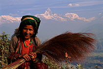 Nepalese woman with the Anapurna Mountains behind, near Pokhara, Nepal.