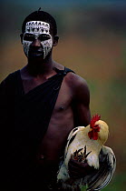 Young Masai man holding chicken at market. Serengeti NP, Tanzania, East Africa
