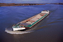 Barge transporting gravel down River Rhone. Villeneuve les Avignon, France, Europe