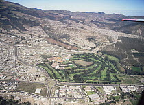 Aerial view of Quito showing well-watered golf course in arid landscape, Ecuador