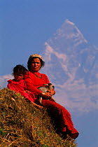 Child and woman with goat kid. Fishtail Mountain in b/ground. Himalayas, Sarangkot, Nepal Annapurna Range