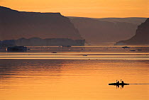 Kayakers, with icebergs in background - ecotourism. Qaanaaq, NW Greenland.