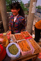 Market trader selling ginseng, Quinghan Dao, N E China