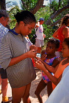 Children with Antiguan racer {Alsophis antiguae}, world's rarest snake, Antigua, W Indies