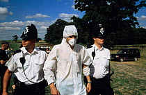 Police arrest protester dressed as alien for pulling up genetically modified (GM) test crop (oil seed rape) Model Farm, Watlington Oxfordshire 1999 July