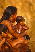 Kayapo woman washing baby in river, Brazil 1994