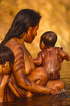 Kayapo woman washing baby in river, Brazil, 1994