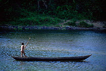 Boy poling / punting canoe across river Maroantsetra, Madagascar.