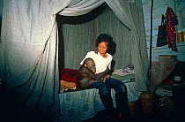 Orang utan orphan {Pongo pygmaeus} with woman, Tanjung Pating, Borneo, Indonesia
