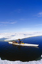 Inuit hunter in kayak with seal skin float, Canadian Arctic