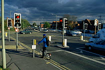 Cyclist at road junction on city cycle path, Bristol, UK