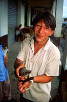 Boy selling young Coati (Nasua sp), Lago Agrio, Amazonia, Ecuador