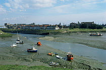 Estuary with boats on intertidal mudflats at low tide, Cardiff Bay, Wales, UK