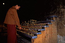 Buddhist monk lighting candles, Kyichu Lhakhang Temple, Paro Valley, Bhutan 2001