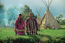 Udege couple in traditional clothing sitting outside traditional tent, Sikhote Alin, Primorsky region, Russia  (Ussuriland).