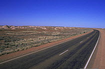 Stewart highway through Outback with spoil mounds from opal mining, Coober Pedy, South Australia