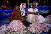 Ladies selling rose garlands in flower market, Calcutta, West Bengal, India