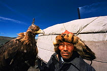 Kazakh nomad with domesticated Golden eagle {Aquila chrysaetos} used for hunting, Tsengel, West Mongolia