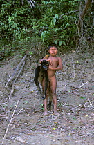 Huaorani indian boy with dead Woolly monkey (Lagothrix genus) Yasuni NP, Ecuador