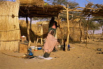 Two Sudanese women beside homes, Darfur Province, West Sudan Democratic Republic, 1986