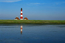 Westerhever lighthouse alongside coastal waters, Schleswig-Holstein NP, Germany