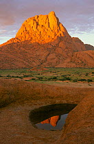 Peak of Spitzkoppe reflected in ephemeral pool, wet season. Damaraland, Namibia