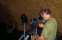 Camerman Jim Clare on location in Trinidad, using an infra red sensitive camera to record bat behaviour in cave and wearing a mask