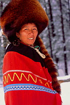 Yi ethnic woman portrait in red panda hat, Lijiang, Yunnan Province, China.  Winter