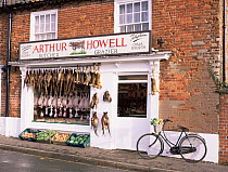 Traditional butchers shop with game hanging outside, Great Walsingham, Norfolk, UK.