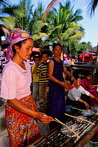Dai woman cooking at market stall (ethnic minority group) Xishuangbanna, Yunnan, China 2002