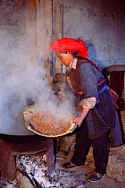 Tibetan ethnic minority group man cooks cattle feed Zhongdian, Yunnan, China. 2002