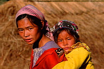 Hani woman and child wearing embroidered clothes with coins. Huangcouba, Yuanyang, Yunnan, China 2001