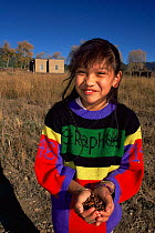Native American girl holding Pixon nuts, Taos Pueblo, New Mexico, USA 1990