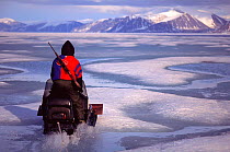 Man on skidoo racing across ice, Baffin Island, Canadian Arctic, Northwest Territories