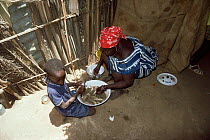 Woman and child cleaning fish, The Gambia