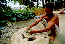 Potter turning clay pot on wheel, Majuli Island, Assam, India