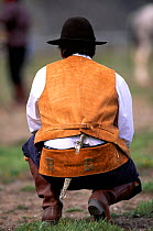 Gaucho at rodeo, rear view kneeling, Chalten, Fitzroy, Patagonia, Argentina, S America