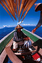Funae fishermen catch Tuna at sunrise in Rakit area, Indonesia. Rakit is a small bamboo raft occupied by custodian who attracts fish with lanterns at night. Boats pay to fish in a Rakit area. 2000