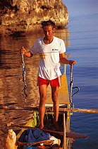 Seasnake fisherman holding seasnakes, Gato island, Philippines.