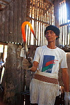 Blacksmith forging large fish hook for hunting Whale sharks, Pamilacan, Bohol, Philippines. 1997