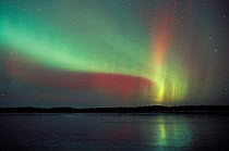 Aurora borealis colours in night sky over frozen lake, northern Finland, November, winter 2002