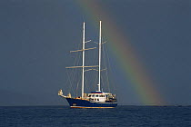 Motor yacht Andando with rainbow in stormy sky, Galapagos Islands