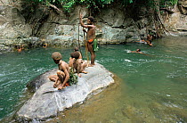 Hagahai tribal people relaxing by river, discovered in 1985, Shraeder Mountains, Papua New Guinea